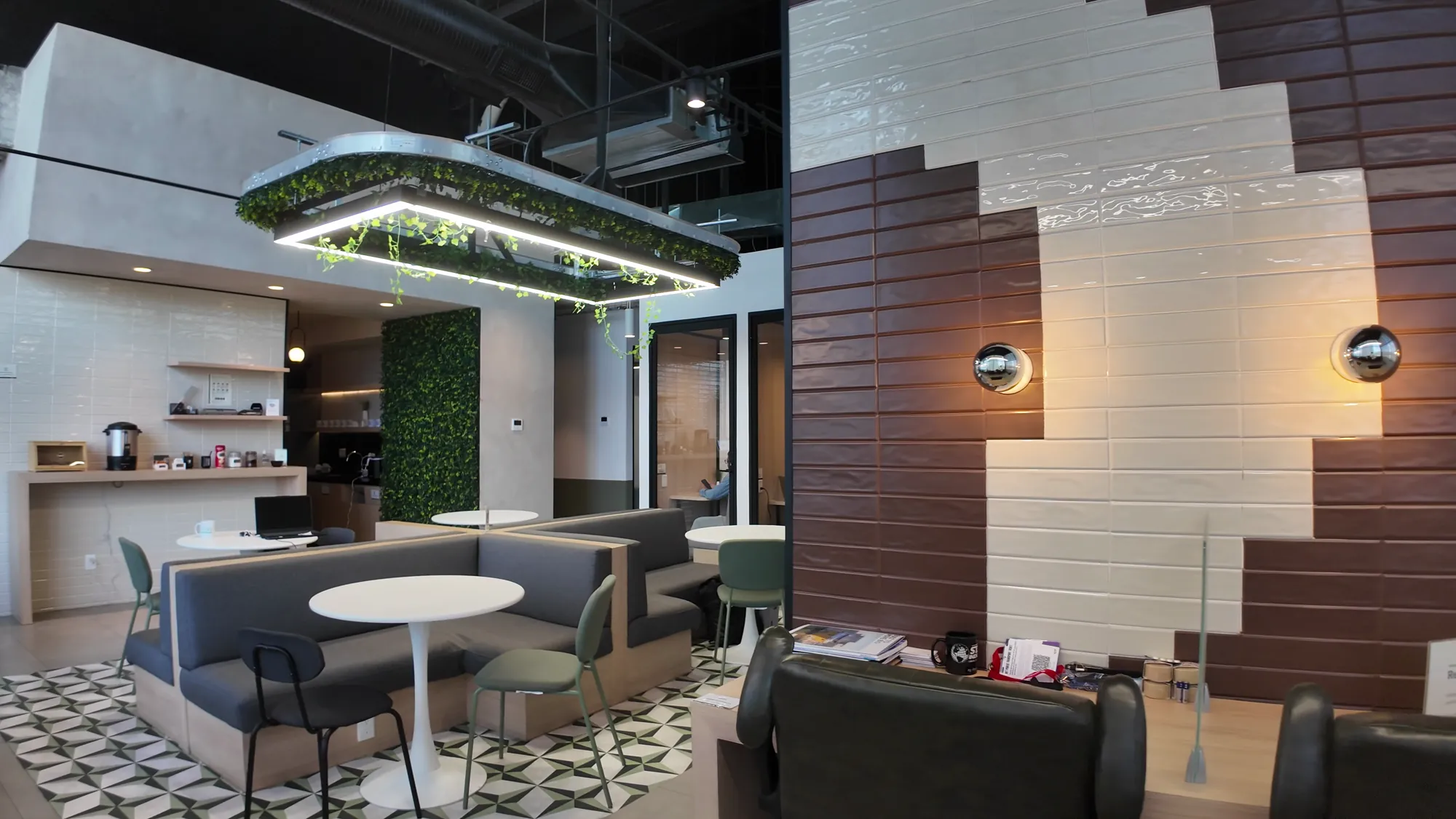 Sala común con sofás, barra de café y piso de mosaico en Think Workspace