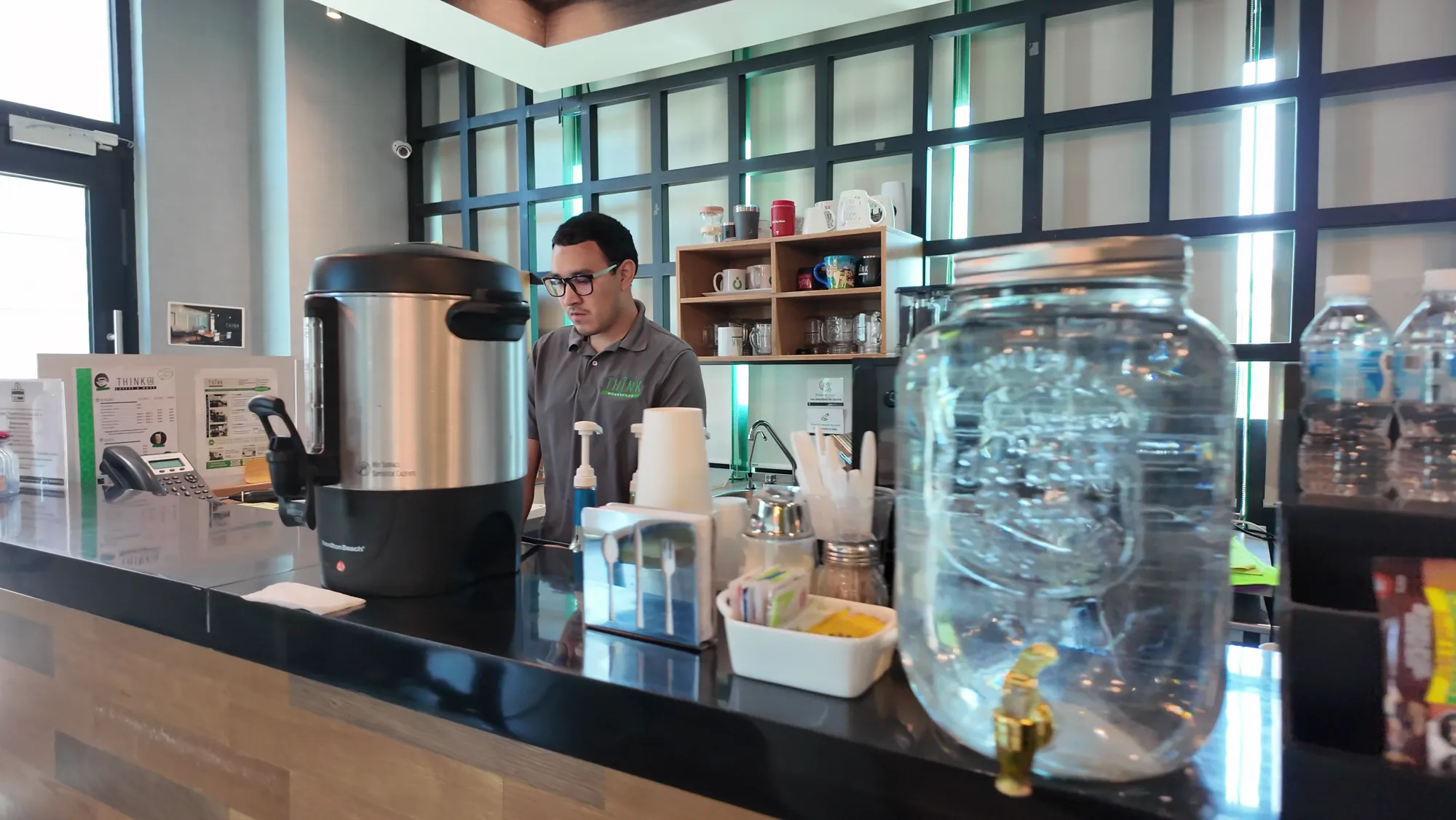 Estación de café y bebidas atendida por staff de Think Workspace